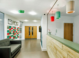 View of the internal entrance area of The Courtrooms, showing a reception desk, a sofa, and individual student postboxes